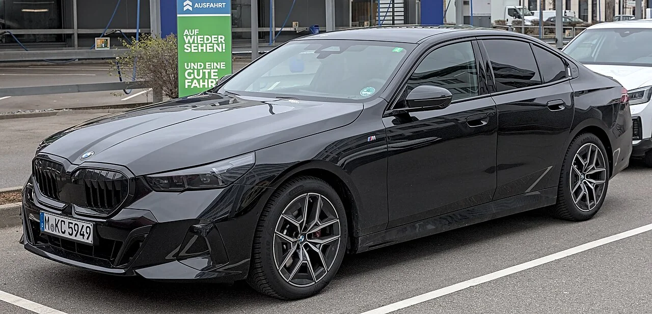 Full front three-quarter view of a black BMW 5 Series G60, shown as a representative business sedan