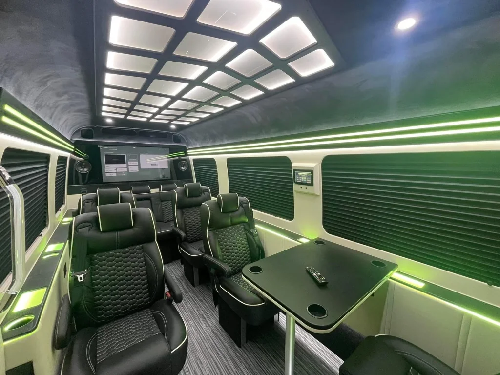 Photograph of a van cabin with tables between black leather seats
